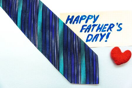 Happy Father's Day inscription with tie and gift box on white background. Greetings and presentsの写真素材