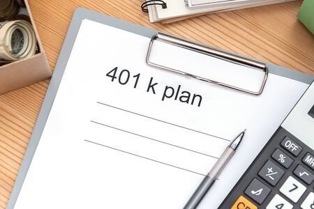 401 K plan list with folder, notepad and calculator on wood.en tableの写真素材
