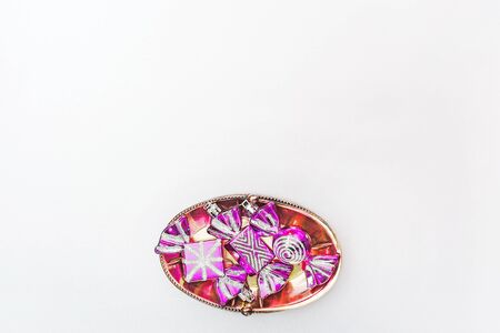 Christmas lilac toys in the form of sweets lie on a silver table, prepared for decorating the...