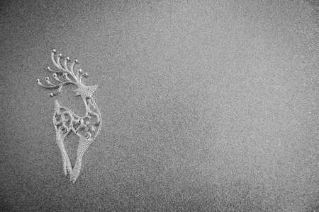 Magical Christmas paper winter background landscape with deer and snow in front of silver light bokeh background. Black and white photo.の写真素材