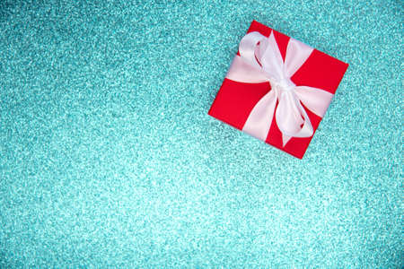 Mock-up poster, red colored New year or Christmas square gift box with white satin bow on texture...