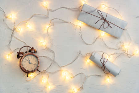 Retro alarm clock and letters, papers with ribbons, glowing garlands flat lay. Vintage clock and...