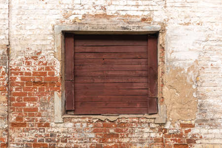 Weathered wall with wooden window, abandoned homeの写真素材