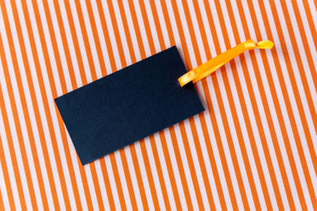 Blank paper card with yellow silk ribbon on color backgroundの写真素材