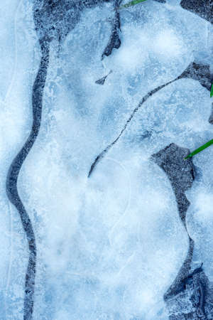 Surface of natural ice covering on water in winter. Ice texture with intersperses of frost, crystals...