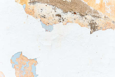 Grunge texture of ancient wall with white chipped stucco