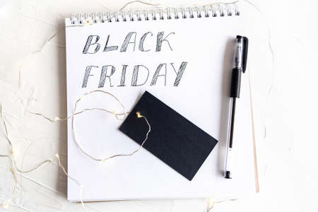 Blank paper card with space for design lying on white textured and lights.