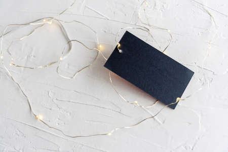 Blank paper card with space for design lying on white textured and lights.の写真素材