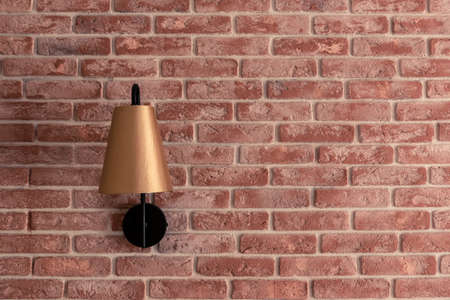 Stylish lamp installed on brick wall against brown curtainの写真素材