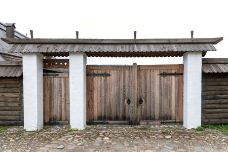 Weathered gate with green roof and fence near rural houseの写真素材