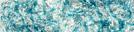 Silver and blue tinsel macro texture for a sparkling Xmas and New Year web banner blurred...