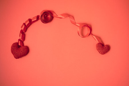 Two hearts and ribbon frame on red background. Valentines day celebration. Love card with copy spaceの写真素材
