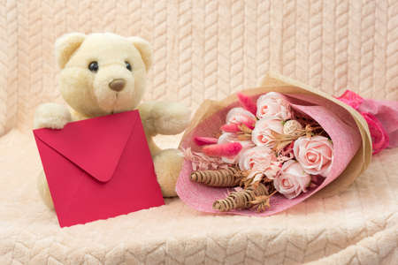 White teddy bear with flowers and envelope with congratulations.の写真素材