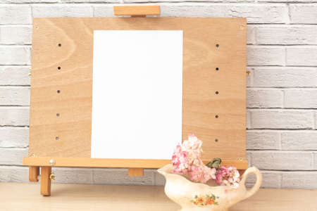 Wooden easel with empty white paperの写真素材