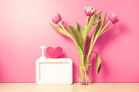 Fresh tulips flowers in glass vase on tableの写真素材