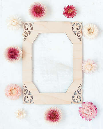 Retro rustic wedding invitation with floral pattern on wooden frame on light background.の写真素材