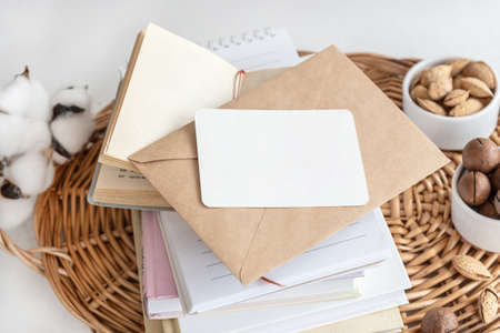 Business card on stack of notebooks with envelope on table