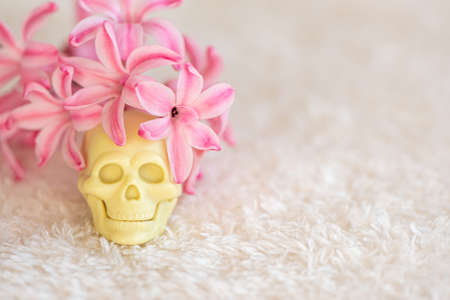 Mexican colorful scull day of dead with flowers on white fluffy fabricの写真素材
