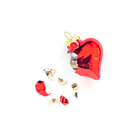 Broken heart shaped Christmas tree bauble on whiteの写真素材