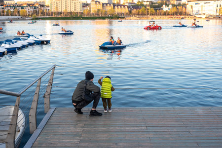 Parent with little boy in vest spends time on wooden pierのeditorial素材