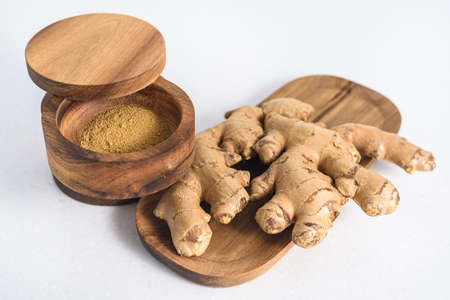 Ginger root and ginger powder in the bowlの写真素材