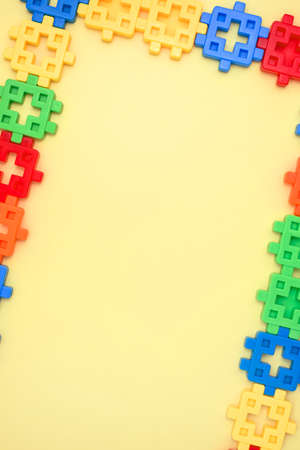 Colorful kids toys vertical frame on yellow background. top view. flat lay. Copy space for text. Concept World Children's Dayの写真素材
