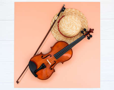 Summer music vacation background. Violin and straw hat on white background with space for your text