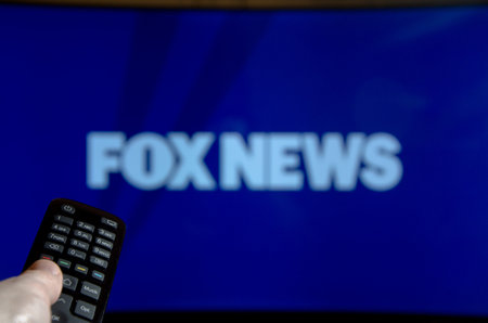 Soest, Germany - January 14, 2018: Man watching FOX News on TV. Fox News is an American basic cable and satellite television news channel owned by the Fox Entertainment Group.のeditorial素材