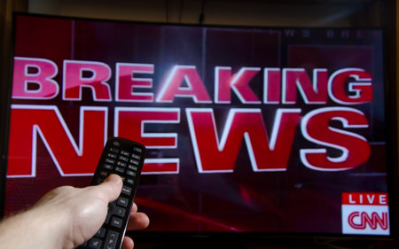 Soest, Germany - January 14, 2018: Man watching CNN Breaking News on TV. Cable News Network (CNN) is an American basic cable and satellite television news.のeditorial素材