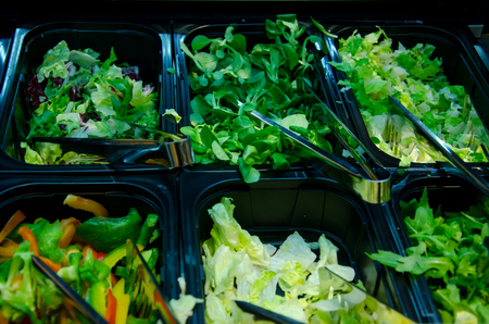 Fresh sliced ââvegetables and salad leaves for sale in the shop.の写真素材