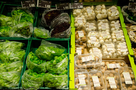 Soest, Germany - December 17, 2018: Fresh mushrooms and lettuce salad on shelf in HIT supermarket.のeditorial素材
