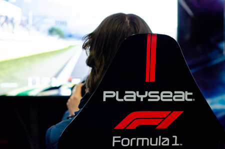 Kyiv, Ukraine - April 12, 2019: Man playing car video games sitting on a Playseat.