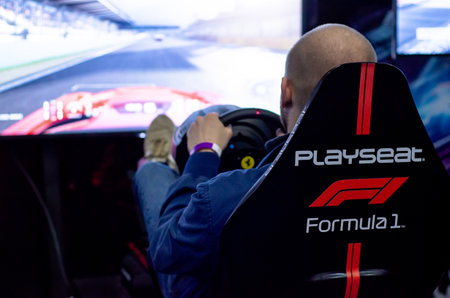 Kyiv, Ukraine - April 12, 2019: Man playing car video games sitting on a Playseat.