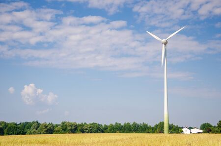 Wind turbine farm power generator in field.