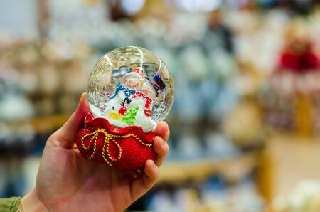 Christmas snowball toy in the hand of a young girl.の写真素材