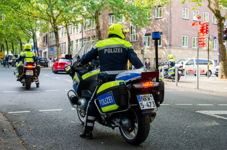 Dortmund, Germany - August 2, 2019: Policeman on motorcycle patrolling the streets. Motorcycle policemans on the street.のeditorial素材