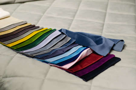 Colorful upholstery fabric samples in the store. Types Of Fabrics.の写真素材