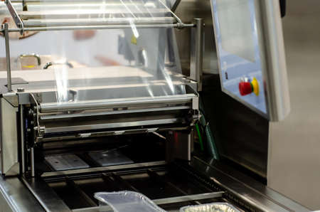 Automatic packaging machine for producing packs from a roll of heat-sealable packaging film