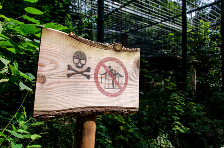 Zoo danger sign "To climb over the fence is prohibited"の写真素材