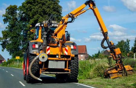 Maintenance of the edge of a road by a brush cutter tractor.の写真素材
