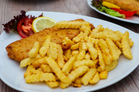 Batter fish with french fries and fresh vegetablesの写真素材
