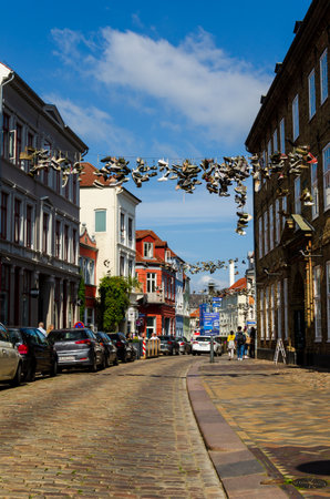 Flensburg, Germany - September 04, 2021: Cityscape with old houses and shoes hanging on wires in...