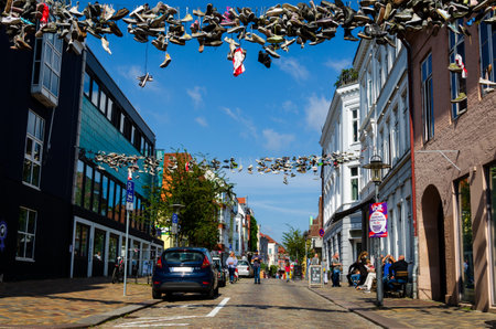 Flensburg, Germany - September 04, 2021: Cityscape with old houses and shoes hanging on wires in Flensburg.のeditorial素材