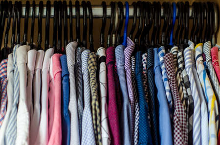Men's shirts on hangers in the wardrobeの写真素材