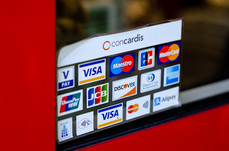 Munster, Germany - April 18, 2022: Various payment options, Discover, JCB, UnionPay, Mastercard, Diners Club International, VISA and Alipay, are seen on the door sticker in a store.のeditorial素材