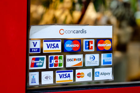 Munster, Germany - April 18, 2022: Various payment options, Discover, JCB, UnionPay, Mastercard, Diners Club International, VISA and Alipay, are seen on the door sticker in a store.のeditorial素材