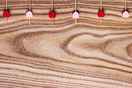 Red and pink Wooden skewers for food with a heart. Wooden background for st Valentine's Day. Flat lay with copy space for text.の写真素材