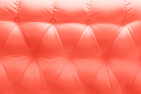 genuine leather upholstery chesterfield style texture painted Living coral color background. Color of the year 2019. Main trend concept.の写真素材