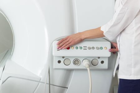 hand on settings buttons of modern mri scanner at hospital, Medical Equipment and Health Care