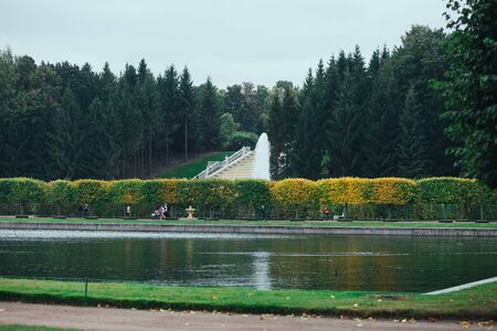 Saint Petersburg, Russia - 18 September 2015 - Trees alley in Peterhof in autumn season with fountaine and pondのeditorial素材